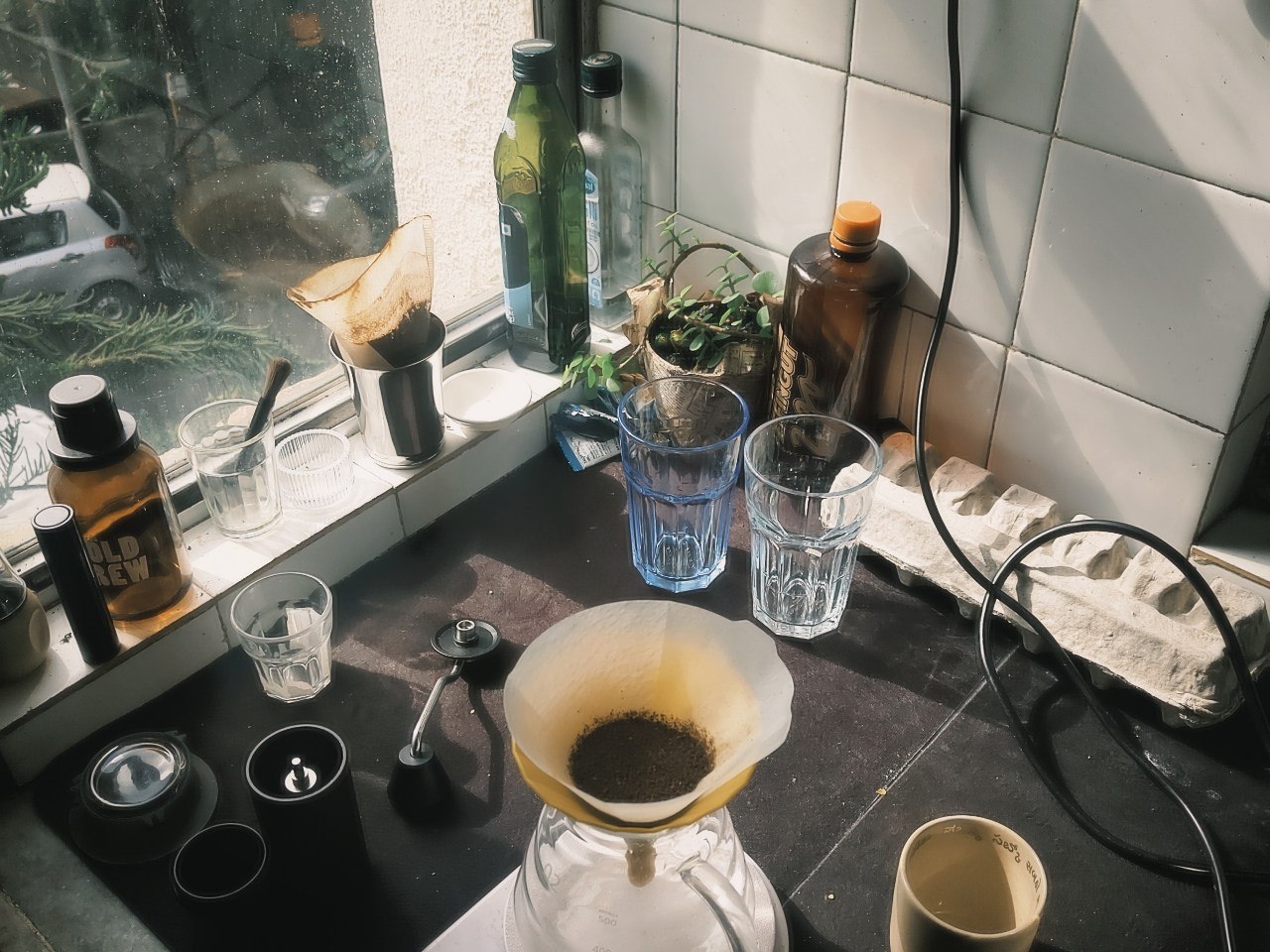 Pour-over brewing on the kitchen counter beside a window